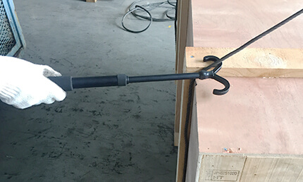 玉掛け用伸縮手鉤棒(さわらん棒)でワイヤーの位置を調整する写真