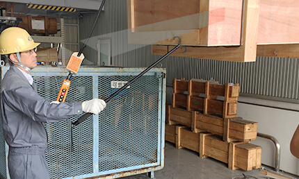 安全な玉掛用手鉤棒(さわらん棒)で吊り荷の振れを制御する写真